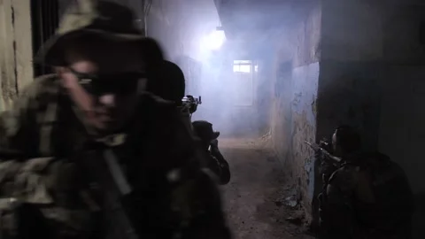 Squad of army men moving inside storming building Stock Footage 138145692
