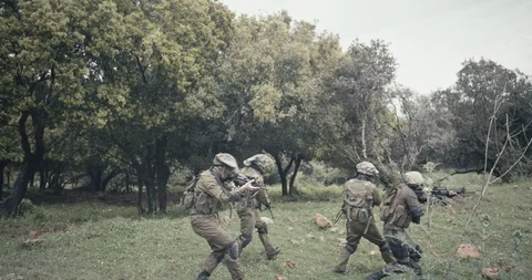 Squad of fully armed commando soldiers during combat in a forest scenery Stock Footage 106683411