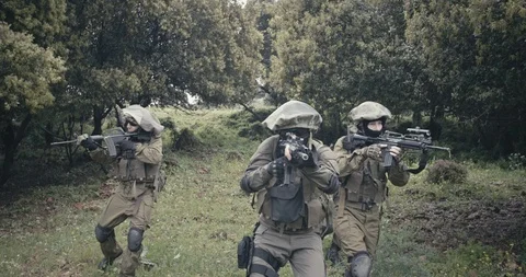 Squad of fully armed commando soldiers during combat in a forest scenery Stock Footage 106683447