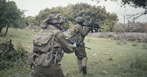 Squad of fully armed commando soldiers during combat in a forest scenery Stock Footage 106683517