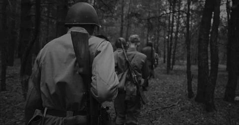 Squad of Soviet soldiers marching in a forest during WWII Stock Photos