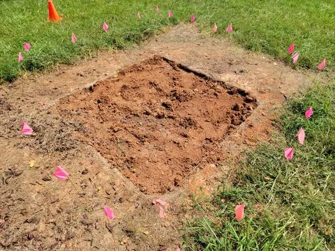 Squae plot of dirt in grass with flags for archeology Stock Photos