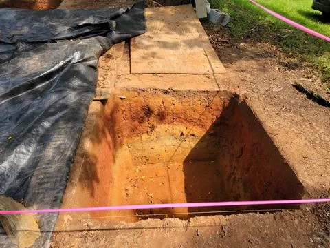Squae plot of dirt or hole in grass for archeology Stock Photos