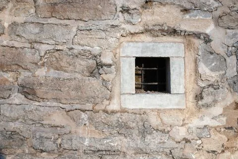 Square barred window in old stone wall, minimal texture Stock Photos