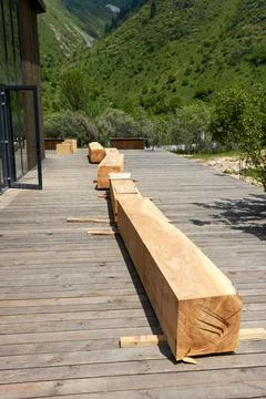 Square bars of the bench made of a single trunk of the Tien Shan spruce Stock Photos