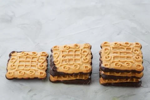 Square biscuits arranged in pattern on light textured background, close-up Stock Photos