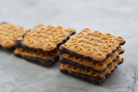 Square biscuits arranged in pattern on light textured background, close-up Stock Photos