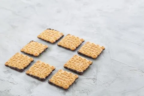 Square biscuits arranged in pattern on light textured background, close-up Stock Photos