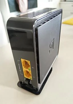 A square black networking device features two yellow Ethernet ports Stock Photos