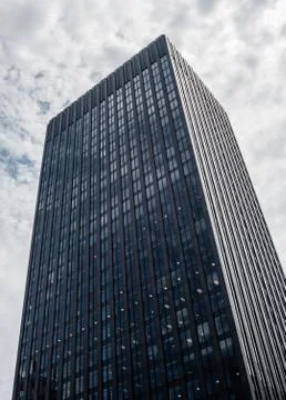 Square black office tower on cloudy sky in Montreal, Quebec, Canada. Stock Photos