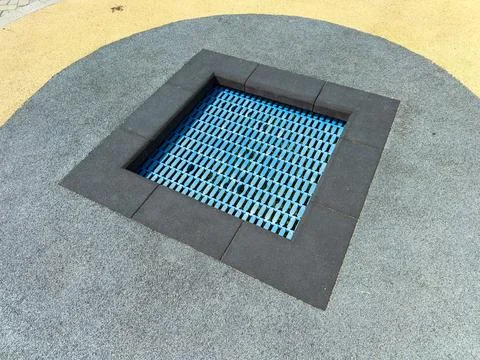Square blue patterned surface in a playground on a sunny day Stock Photos