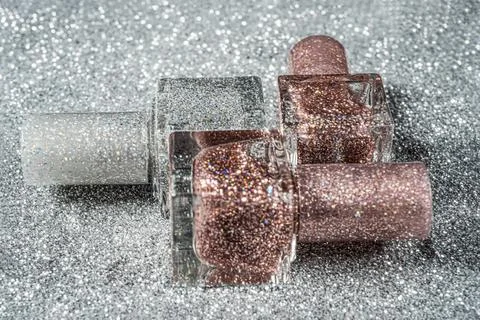 Square bottle of lacquer with sequins close-up Stock Photos
