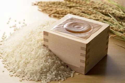 A square box filled with sake. A drop of ripple. 写真素材