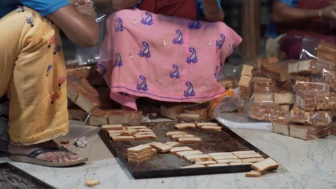 Square bread slices being packed in plastic bags by bakery workers in India Stock Footage 113414659