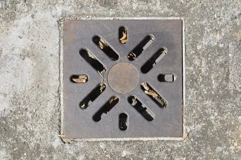 Square cast iron drain grate in concrete sidewalk Stock Photos