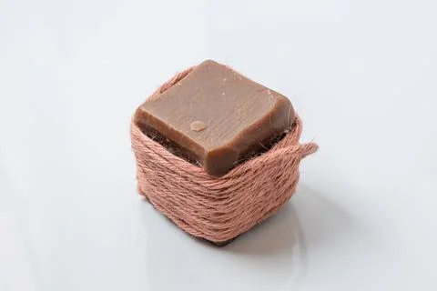 A square chocolate bar wrapped in rustic twine, showcasing a simple and elega Stock Photos