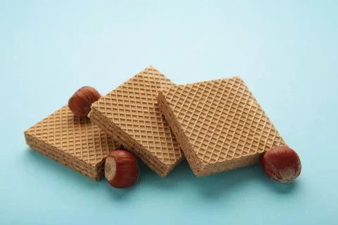 Square chocolate wafer biscuits with hazelnut on blue background. Stock Photos