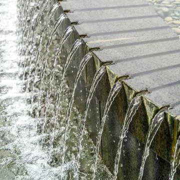 Square Close up view of the round stone pool fountain with glistening clear Stock Photos
