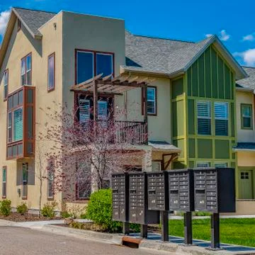 Square Cluster mailboxes on the sidewalk in front of houses viewed on a sunny Foto stock