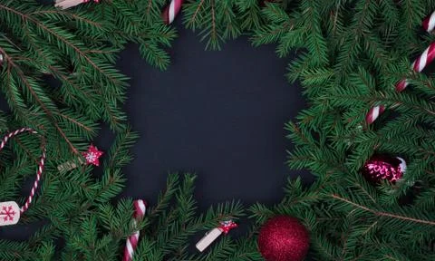 Square composition frame of fir branches and decorative toys on black backgro Stock Photos