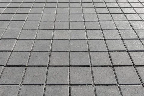 Square concrete pavers form a repeating geometric pattern ideal for urban p.. Stock Photos