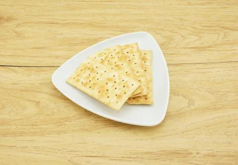 Square crackers in a white plate Stock Photos