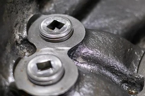 Square drive threaded metal plugs installed on heavy transmission casing in.. Stock Photos