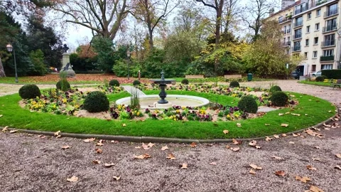 Square du Val d'Osne resting urban park with circular flower bed and autumn Stock Footage 323982497