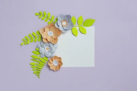 Square frame card with grey brown color paper flowers on pastel violet blue Stock Photos