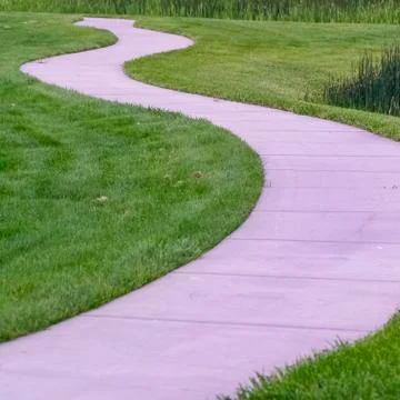 Square frame Close up of a pathway curving through a lush grassy terrain with a Stock Photos
