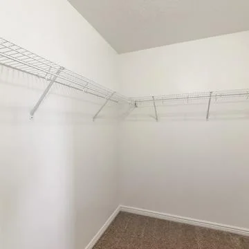 Square frame Empty storage room with wall mounted white metal shelves and hooks Foto stock