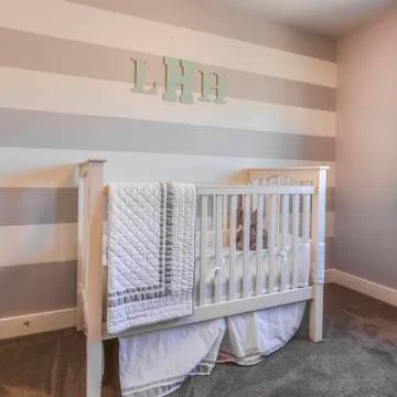 Square frame Interior of a nursery with white crib and monogram letters on the 스톡 사진