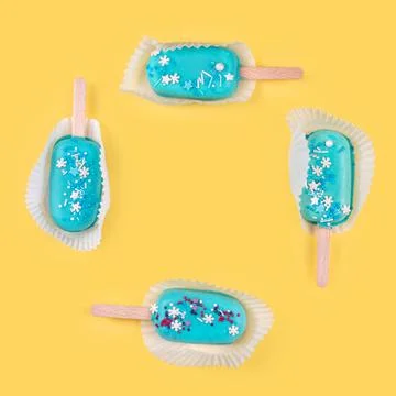 Square frame made of blue mint ice cream popsicles on yellow background. Tast 库存照片