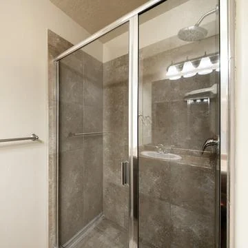 Square frame Shower stall inside a bathroom with glass panel and metal frames Stock Photos
