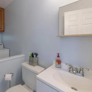 Square frame Small bathroom and laundry combo interior with sink and wooden Stock Photos