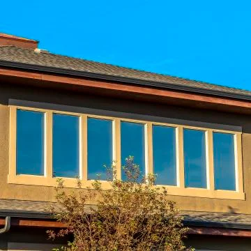 Square frame Upper storey of a house lined with rectangular windows against Stock Photos
