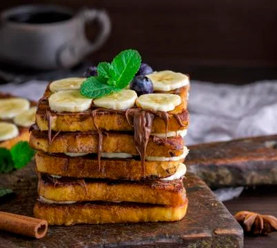 Square fried bread slices with chocolate and banana slices Stock Photos