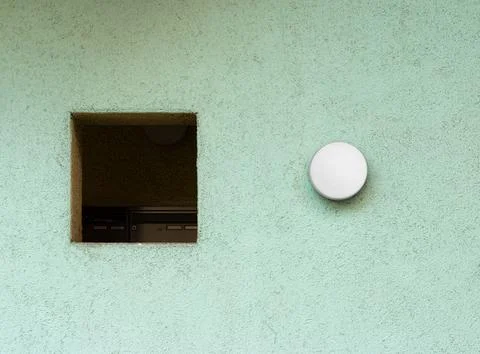 Square hole and a round object in a wall, designed to fit and provide illuminati Stock Photos