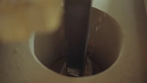 A square iron beam that turns a conrecte wheel that pulvers grain Stock Footage 85215437