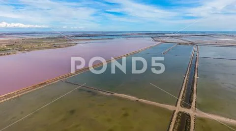 Square lagoons for evaporation of salt and a pond with red water. Stock Photos