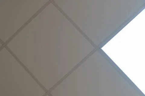 Square lamp on a white office ceiling. Interior design in the office. A fluor Stock Photos