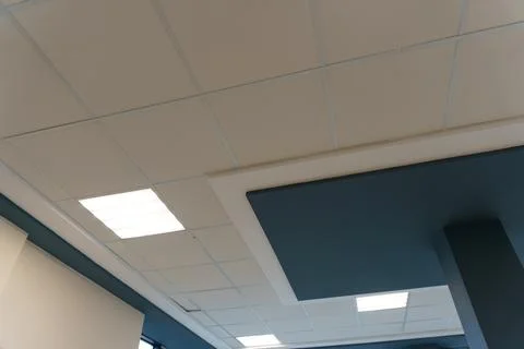Square lamp on a white office ceiling. Interior design in the office. A fluor Stock Photos