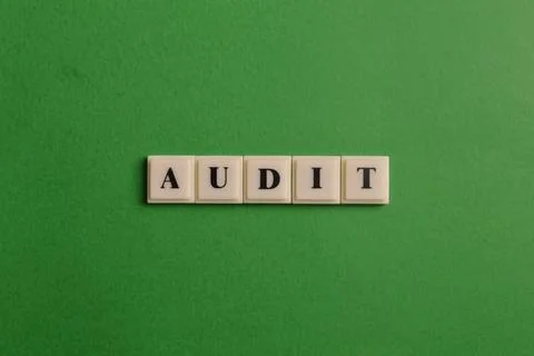 Square letters with text AUDIT isolated on green background 库存照片