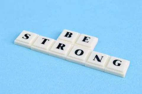 Square letters with text BE STRONG isolated on a blue background Foto stock