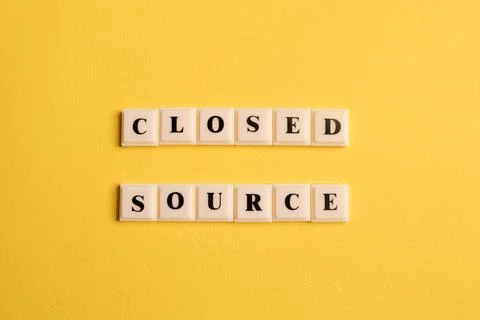 Square letters with text CLOSED SOURCE isolated on yellow background 库存照片