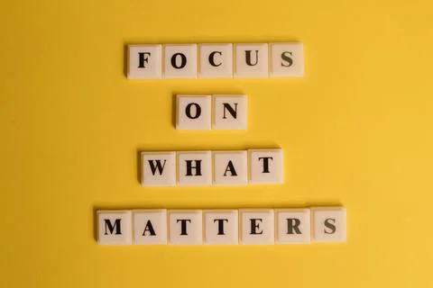 Square letters with text FOCUS ON WHAT MATTERS isolated on yellow background 스톡 사진