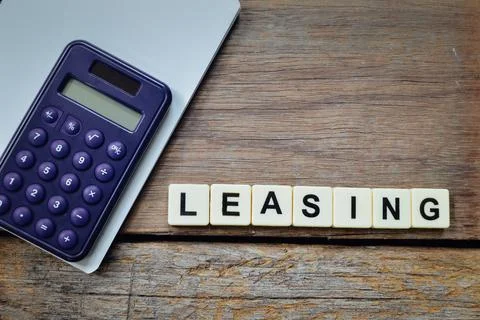 Square letters with text LEASING over wooden background. Stock Photos