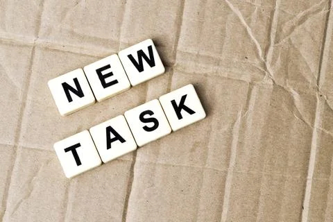 Square letters with text NEW TASK over cork board background. Foto stock