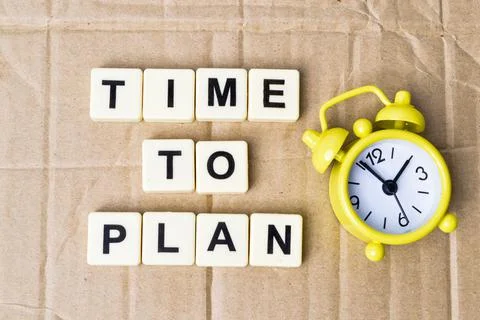 Square letters with text TIME TO PLAN over cork board background. Stock Photos