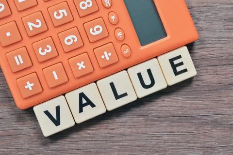 Square letters with text VALUE over wooden background. Stock Photos